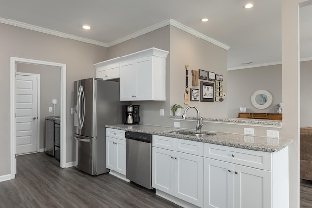 kitchen with light stone counters, dark wood finished floors, stainless steel appliances, white cabinets, and a sink