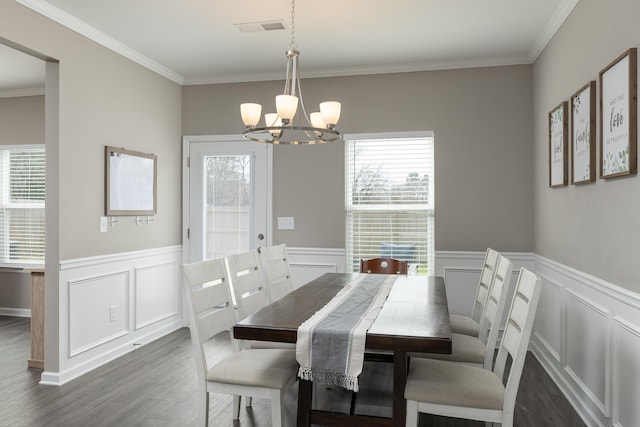 dining area with dark wood-style floors, ornamental molding, a chandelier, and visible vents