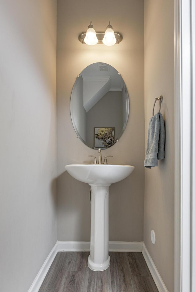 bathroom with baseboards and wood finished floors