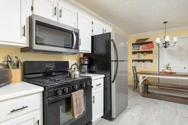 kitchen with a chandelier, white cabinets, stainless steel appliances, and ornamental molding