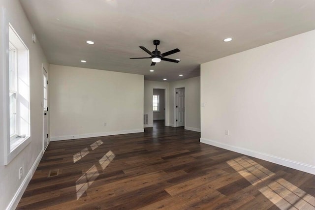 empty room with ceiling fan and dark hardwood / wood-style flooring