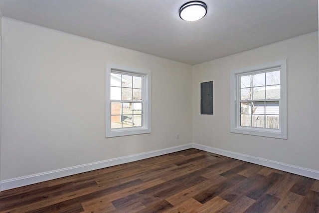 empty room with dark wood-type flooring and electric panel