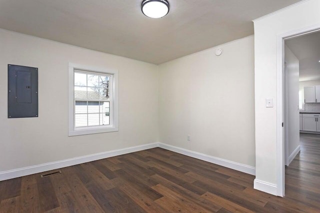 unfurnished room with dark hardwood / wood-style flooring and electric panel