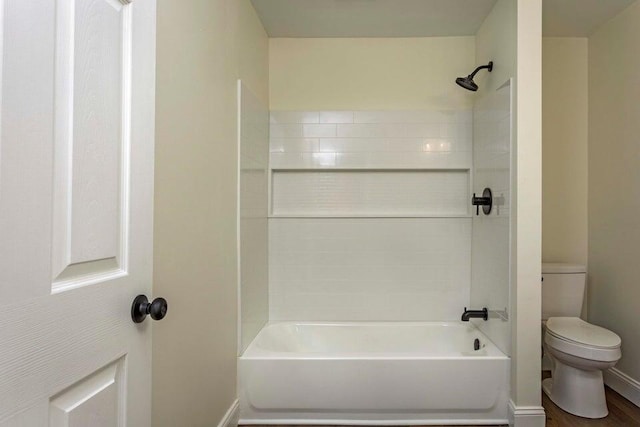 bathroom featuring wood-type flooring, shower / bathtub combination, and toilet