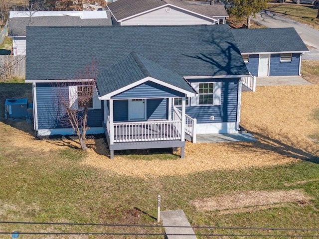 rear view of property featuring a yard and central AC unit