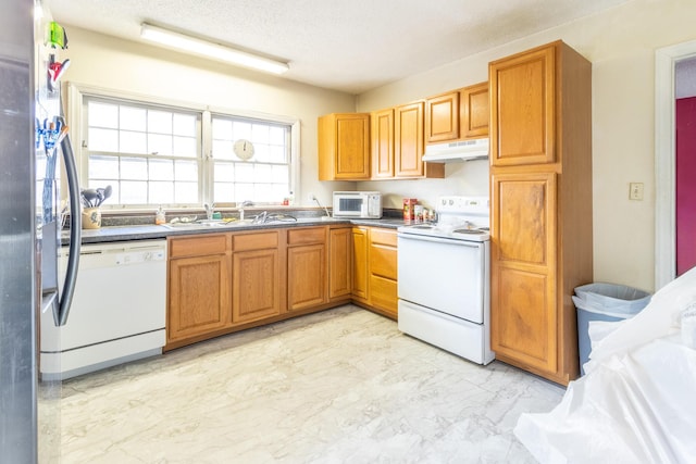 kitchen featuring sink, white appliances, and a textured ceiling