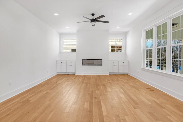 unfurnished living room with ceiling fan and light hardwood / wood-style flooring