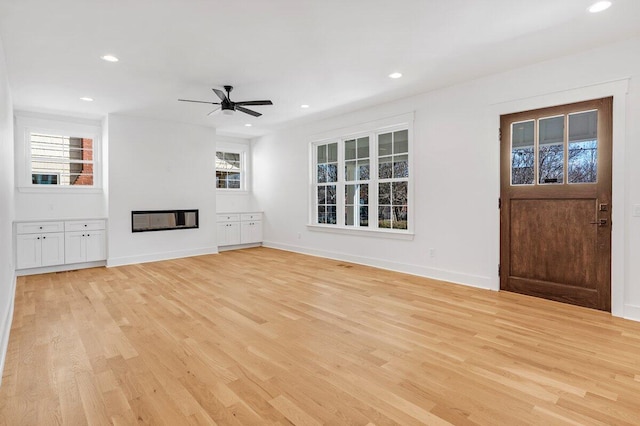 unfurnished living room with ceiling fan, light hardwood / wood-style floors, and a healthy amount of sunlight