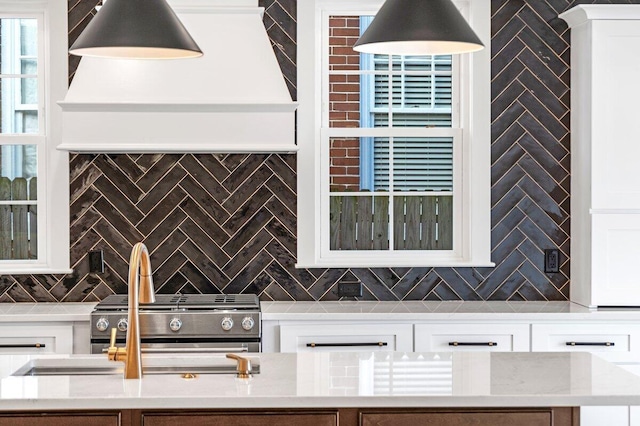 kitchen with white cabinetry, light stone counters, and tasteful backsplash