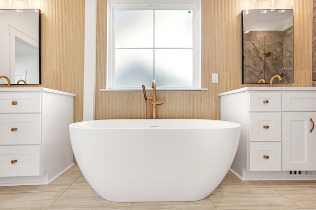 bathroom featuring tile patterned floors, vanity, and a bath