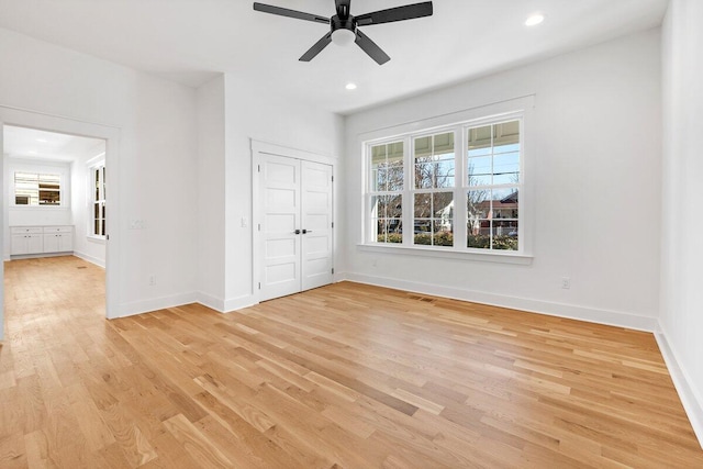 unfurnished bedroom with ceiling fan, a closet, and light hardwood / wood-style flooring