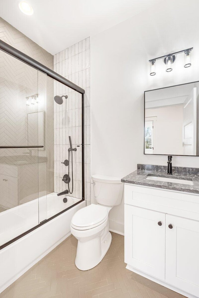 full bathroom with vanity, shower / bath combination with glass door, and toilet