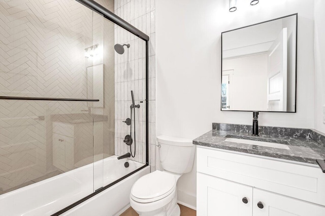 full bathroom featuring enclosed tub / shower combo, vanity, and toilet