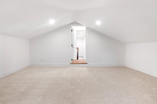 additional living space with lofted ceiling and light carpet