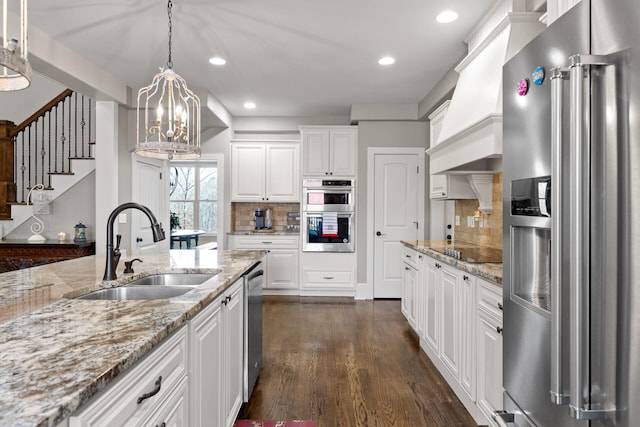 kitchen with sink, white cabinetry, tasteful backsplash, decorative light fixtures, and appliances with stainless steel finishes