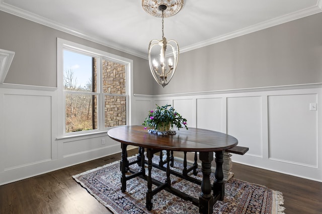 dining area featuring dark hardwood / wood-style flooring, a notable chandelier, and crown molding