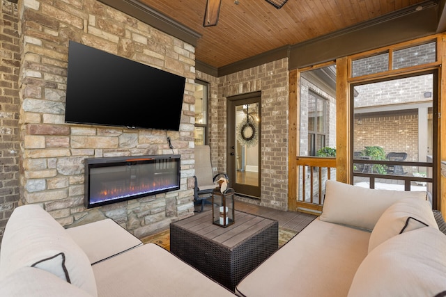 living room featuring wood ceiling and an outdoor stone fireplace