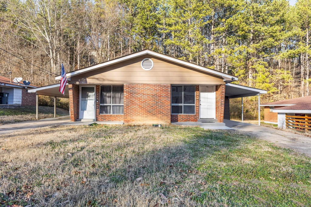 ranch-style home featuring a carport and a front yard