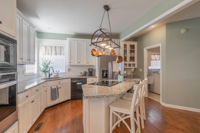 kitchen with pendant lighting, white cabinets, and black appliances