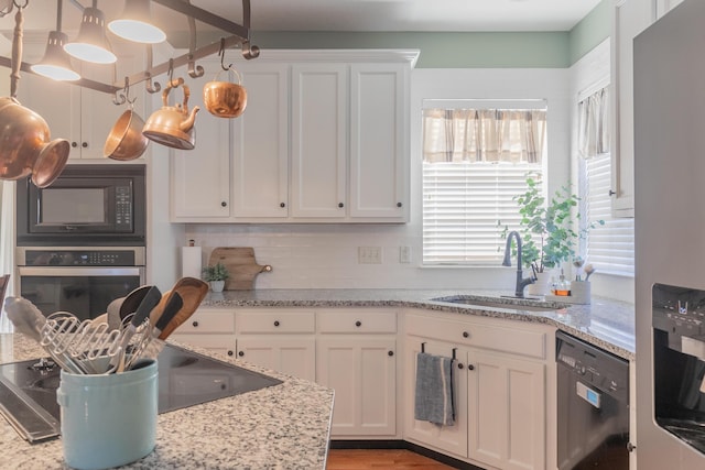 kitchen featuring sink, black appliances, and white cabinets