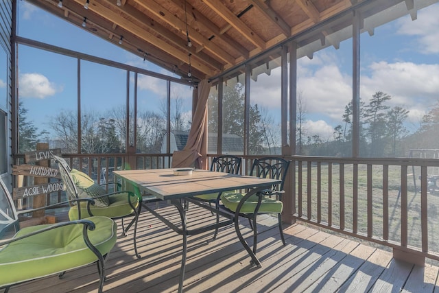 sunroom / solarium featuring a healthy amount of sunlight and vaulted ceiling