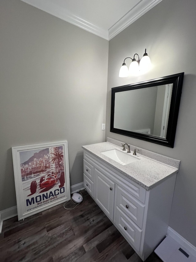 bathroom with hardwood / wood-style flooring, ornamental molding, and vanity