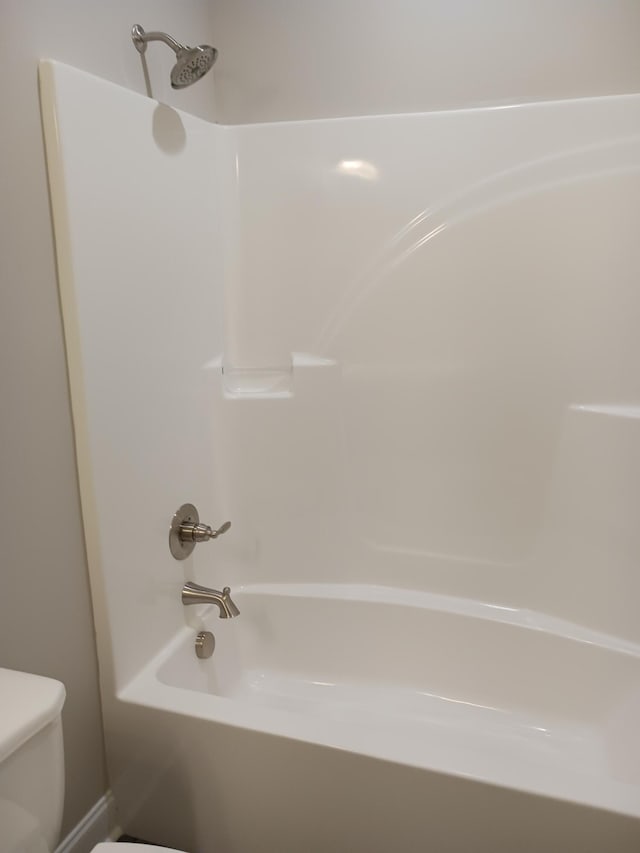 bathroom with bathing tub / shower combination and toilet