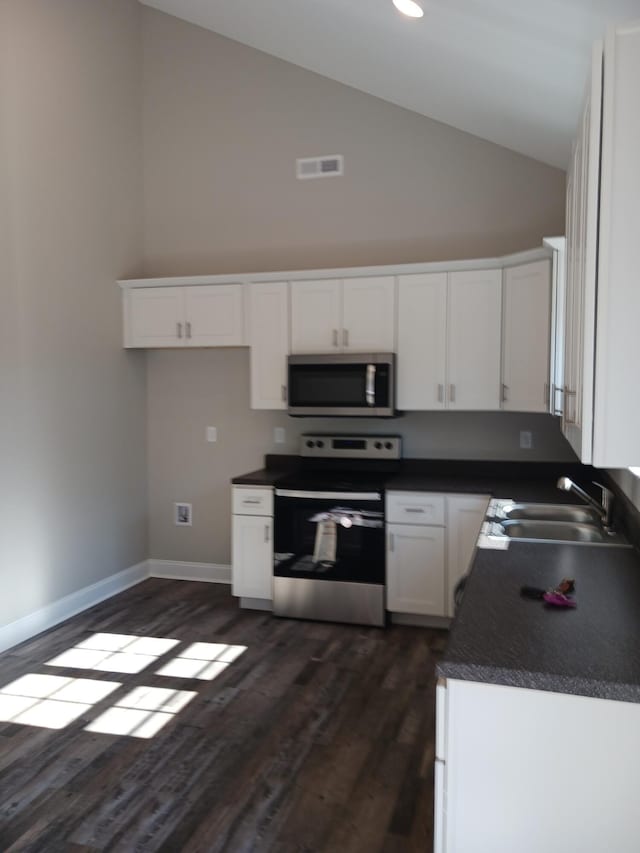 kitchen featuring sink, appliances with stainless steel finishes, white cabinetry, high vaulted ceiling, and dark hardwood / wood-style floors