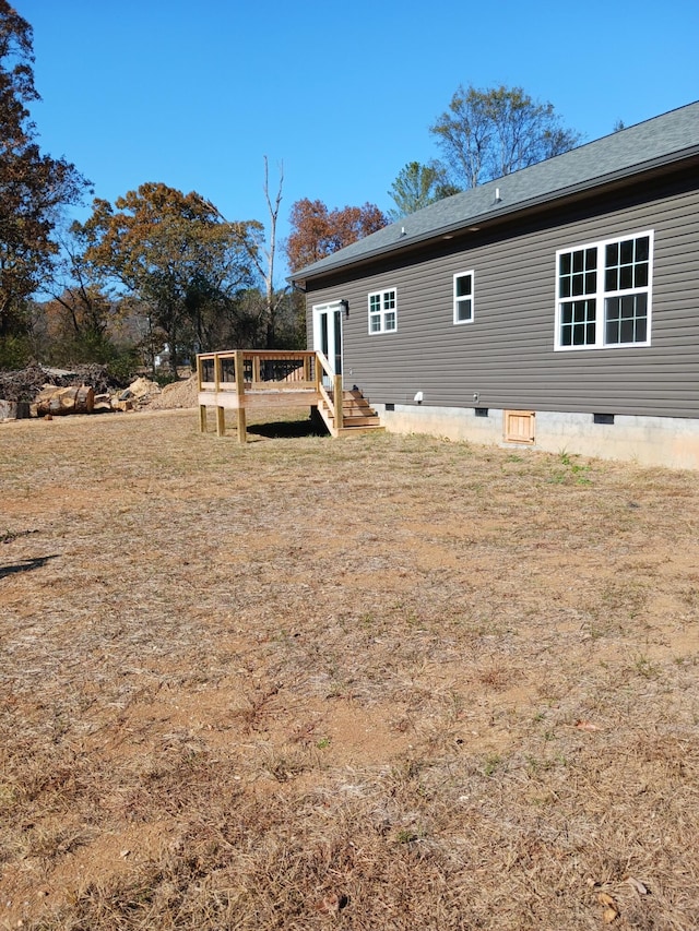 rear view of property featuring a yard and a deck