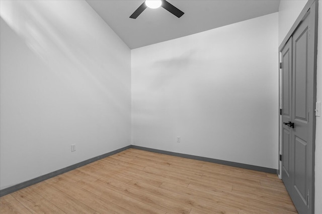 spare room with baseboards, a ceiling fan, and light wood-style floors