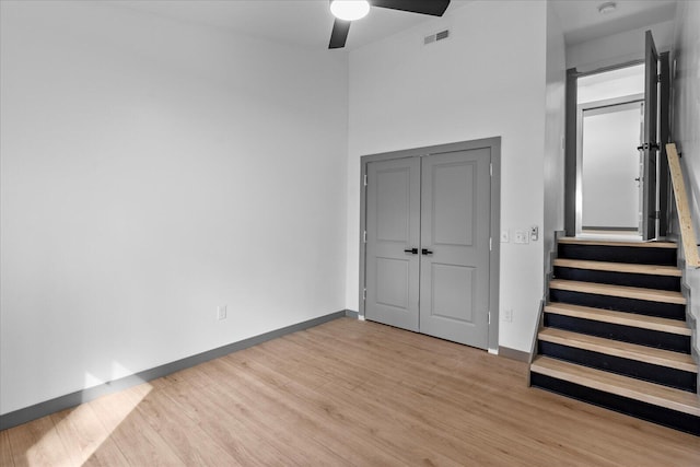 unfurnished bedroom with a ceiling fan, light wood-type flooring, visible vents, and baseboards