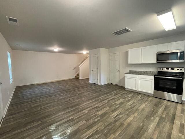 kitchen with white cabinetry, stainless steel appliances, and dark hardwood / wood-style floors