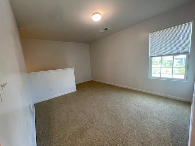 unfurnished room with dark carpet