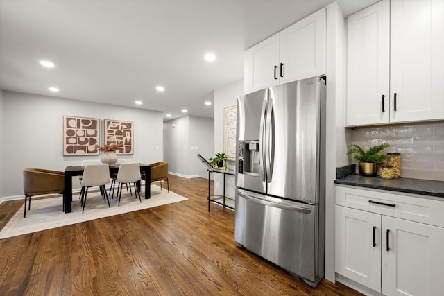 kitchen featuring stainless steel refrigerator with ice dispenser, white cabinetry, dark hardwood / wood-style floors, and backsplash