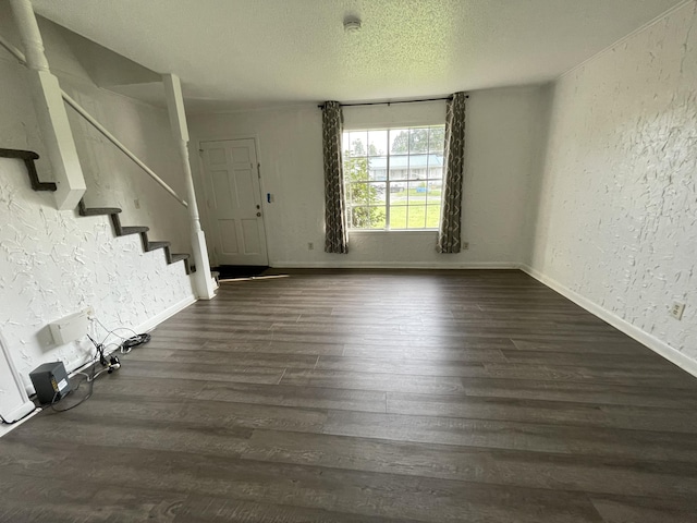 entryway with dark wood-type flooring and a textured ceiling