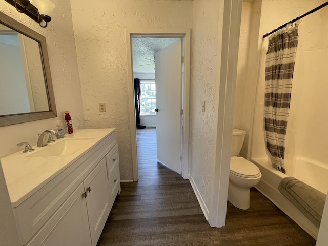 full bathroom with toilet, a textured ceiling, vanity, shower / bathtub combination with curtain, and hardwood / wood-style flooring