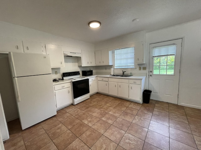 kitchen featuring white refrigerator, sink, white cabinets, and electric range