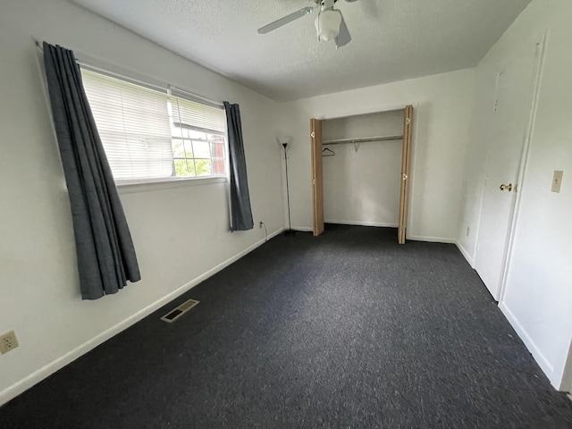 unfurnished bedroom with a textured ceiling, a closet, and ceiling fan