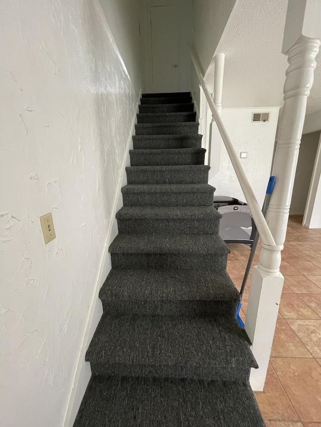 stairway with tile patterned flooring