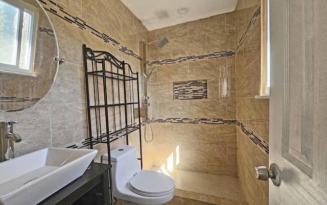 bathroom featuring tile walls, vanity, toilet, and tiled shower