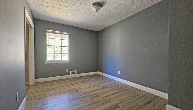 empty room featuring hardwood / wood-style floors and a textured ceiling