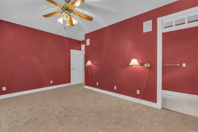 empty room featuring ceiling fan, carpet, and a textured ceiling