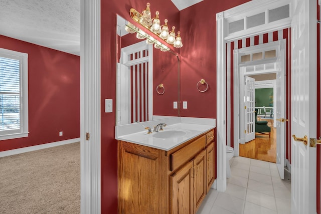 bathroom with vanity, toilet, tile patterned flooring, and a textured ceiling