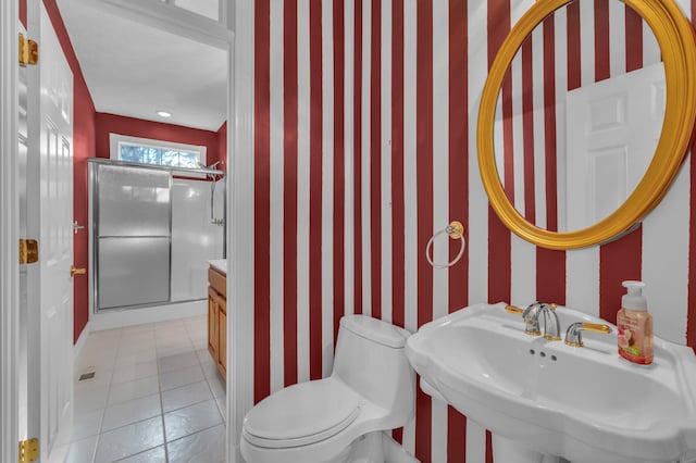 bathroom featuring a shower with shower door, sink, tile patterned floors, and toilet