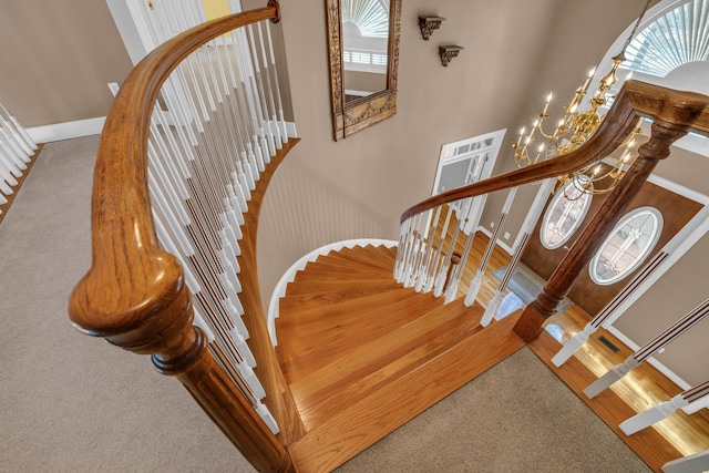 stairway featuring carpet and a notable chandelier