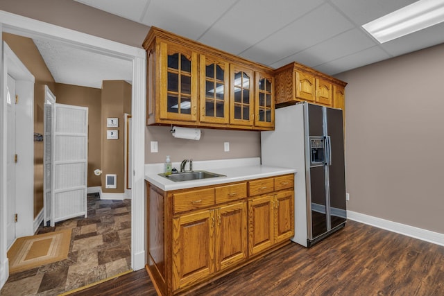 kitchen featuring dark wood-type flooring, sink, black refrigerator with ice dispenser, and a drop ceiling