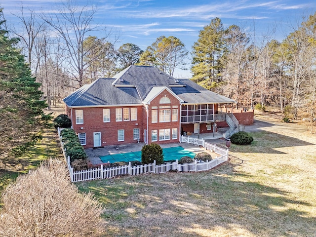 back of house with a yard, a sunroom, a patio, and a covered pool