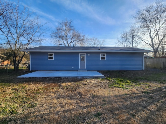 view of front of house with a patio, a front yard, and fence