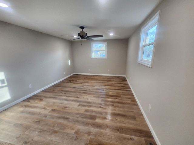 empty room with a ceiling fan, baseboards, and wood finished floors