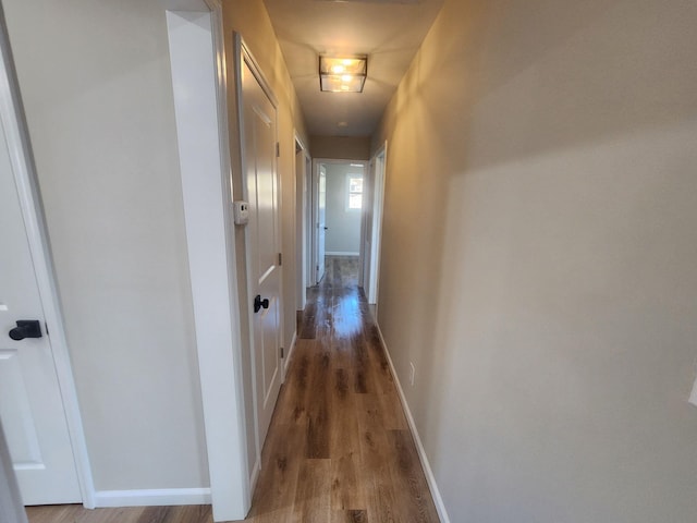 hall with wood finished floors and baseboards